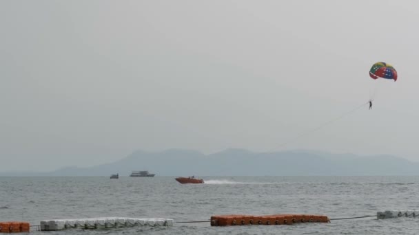 Parasailing, člověk letí na padáku za lodí. Pattaya, Thajsko — Stock video