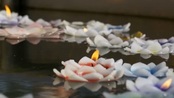 Velas coloridas em forma de lótus flutuando na água em um templo budista. Pattaya. Tailândia . — Vídeo de Stock