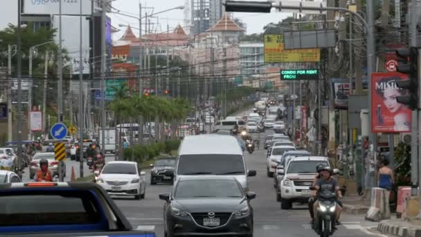 Motos e carros dirigem ao longo das estradas asiáticas. Ruas tailandesas cheias de trânsito. Tailândia, Pattaya — Vídeo de Stock