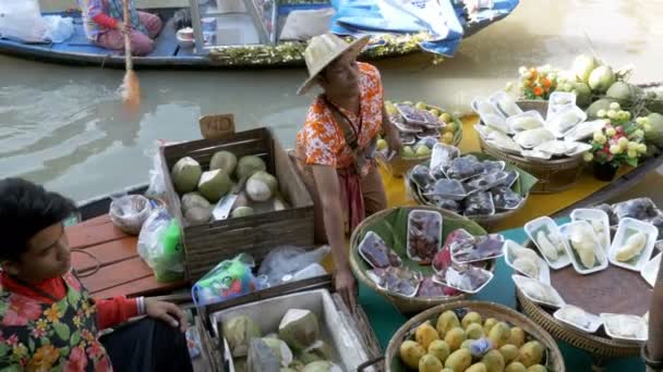 Asiatiska säljare på liten båt med frukt och grönsaker säljer varorna. Pattayas flytande marknad — Stockvideo