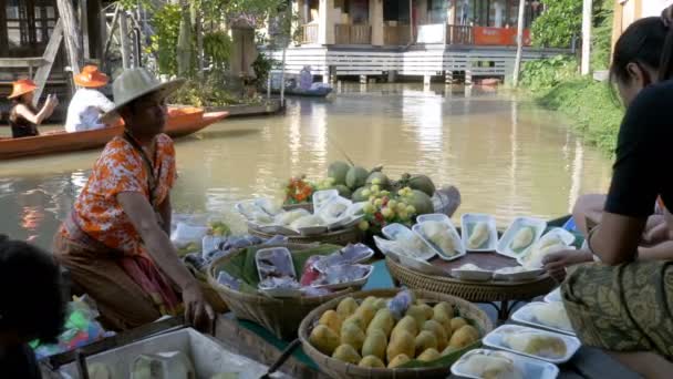 Vendedor asiático em pequeno barco com frutas e legumes vende as mercadorias. Pattaya Mercado Flutuante — Vídeo de Stock