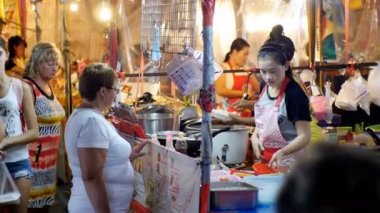 Asyalı kadın satıcı yemek hazırlar ve Street gece pazarı üzerinde satmak. Tayland.