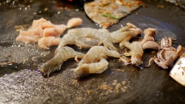 Cibo asiatico di strada. Frutti di mare Gamberetti, calamari, polpo Cucinare su una padella grande. Tailandia . — Video Stock