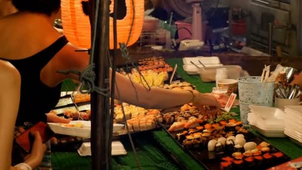 Sushi asiático en el mostrador en el mercado de comida nocturna de Jomtien. Pattaya, Tailandia — Vídeos de Stock