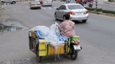 Motosikletler ve arabalar Asya yolları boyunca sürerler. Trafikle dolu Tayland caddeleri. Tayland, Pattaya