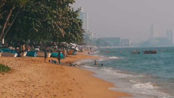 海滩的海岸线。人们沐浴在海里, 水在沙滩上嬉戏, 海浪拍打着海滩。泰国。帕塔亚. — 图库视频影像