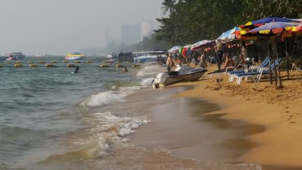 Linha costeira da praia. As pessoas tomam banho no mar, passeios de água, batidas de ondas na costa arenosa. Tailândia. Pattaya. . — Vídeo de Stock