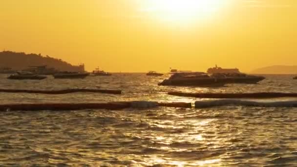 Pôr-do-sol vermelho no mar com barcos balançando nas ondas. Tailândia. Pattaya. — Vídeo de Stock
