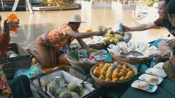 Asiatiska säljare på liten båt med frukt och grönsaker säljer varorna. Pattayas flytande marknad — Stockvideo