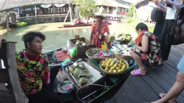Азиатский продавец на маленькой лодке с фруктами и овощами продает товар. Плавучий рынок Паттайи — стоковое видео
