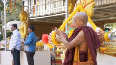 Keşiş altın Buda'nın tapınağında bir dokunmatik ekrana sahip cep telefonu kullanır. Tayland