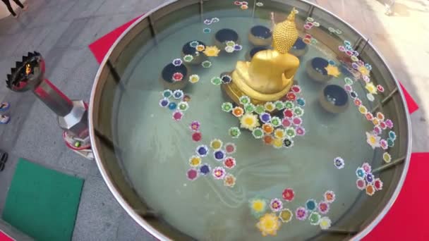 Kleurrijke kaarsen in de vorm van de Lotus drijvend op het Water in een boeddhistische tempel. Thailand. — Stockvideo