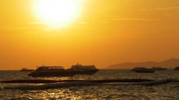 Pôr-do-sol vermelho no mar com barcos de silhueta balançando nas ondas. Tailândia. Pattaya. — Vídeo de Stock