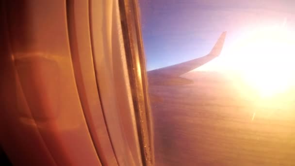 Blick aus dem Fenster eines Passagierflugzeugs bei Sonnenuntergang auf Landschaft und Horizont. — Stockvideo