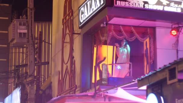 Striptérka dívka točí na stožár na balkóně. Walking Street v Pattaye v noci. Thajsko. — Stock video