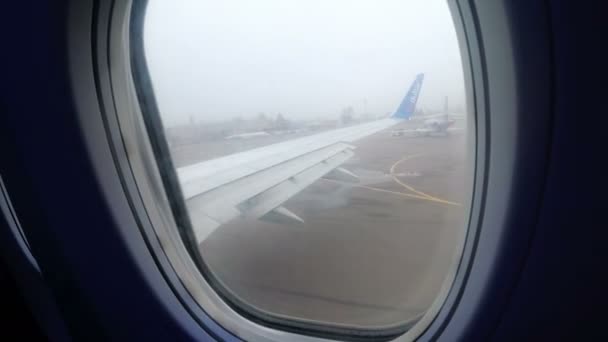 Kilátás az ablakból egy utasszállító repülőgép manőverezési végig a kifutón, a ködbe — Stock videók