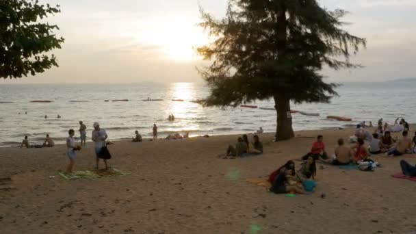 La gente está descansando en la playa tropical al atardecer. Pattaya, Tailandia — Vídeo de stock