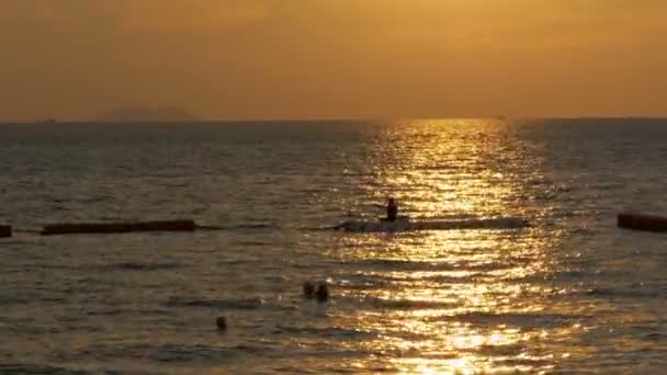 Solnedgang over havet og silhuetten af en mand, der fisker på fortrængeren. Pattaya, Thailand – Stock-video