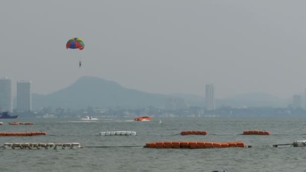 Parasailing, um homem está voando em um paraquedas para um barco. Pattaya, Tailândia — Vídeo de Stock