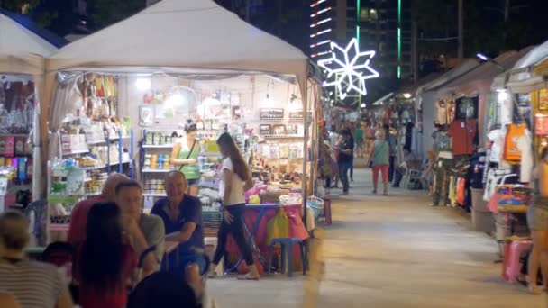 Az emberek séta ázsiai utcai élelmiszer éjszakai piac a Jomtien strandtól. Thaiföldön, Pattaya — Stock videók