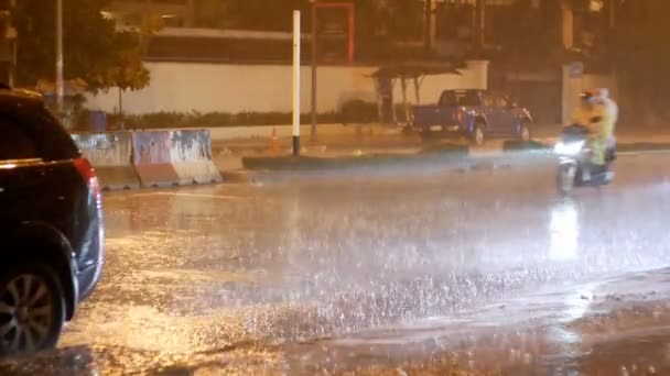 Tropische Regenfälle in der Nacht auf der Straße in Asien. Autos stehen und fahren bei starkem Regen. Thailand — Stockvideo