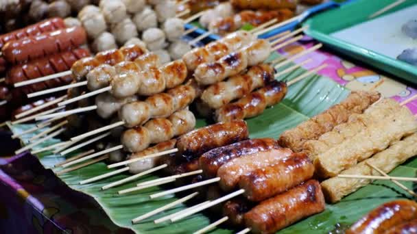 Salsichas grelhadas cozidas são vendidas na exibição da bandeja asiática. Comida tailandesa tradicional . — Vídeo de Stock