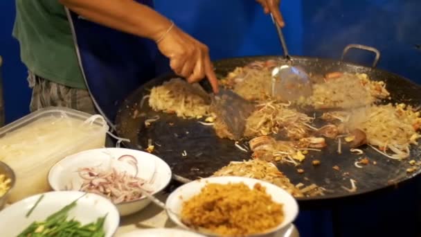 Asian Street food. Fisk och skaldjur, ris nudlar med ägg matlagning på en stor stekpanna. Slow Motion. Thailand — Stockvideo