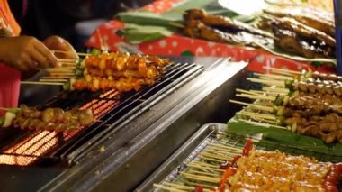 Asya sokak gıda. Satıcı bitmiş şiş kebap Ahşap şiş üzerinde sebze üstünde belgili tanımlık sayaç ile