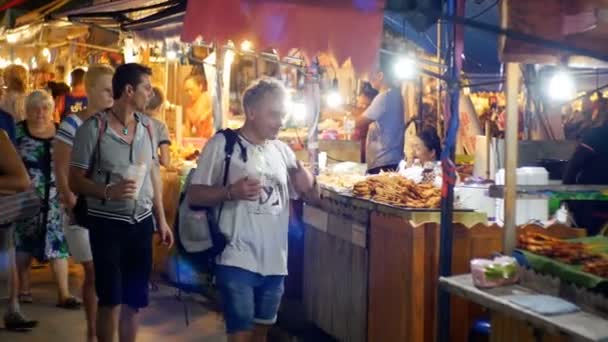 Lidé chodí kolem trhu s potravinami Jomtien noc. Čítače s asijskou kuchyní. Pattaya, Thajsko — Stock video