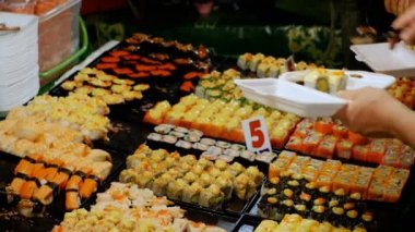 Üstünde belgili tanımlık sayaç Jomtien gece gıda pazarında Asya suşi. Pattaya, Tayland