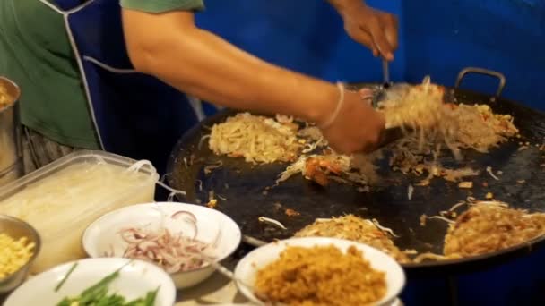 Asian Street food. Fisk och skaldjur, ris nudlar med ägg matlagning på en stor stekpanna. Slow Motion. Thailand — Stockvideo