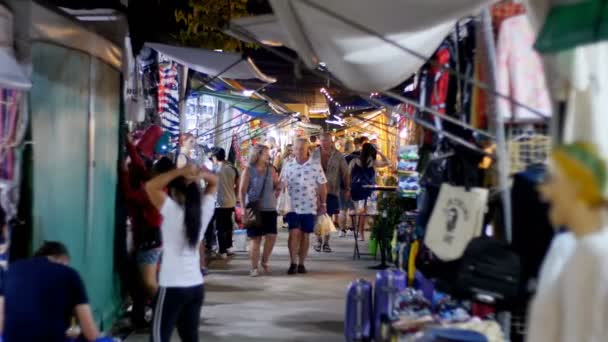 Ludzie chodzą w azjatyckiej ulicy Odzież nocnego targu przy plaży Jomtien. Pattaya, Tajlandia — Wideo stockowe