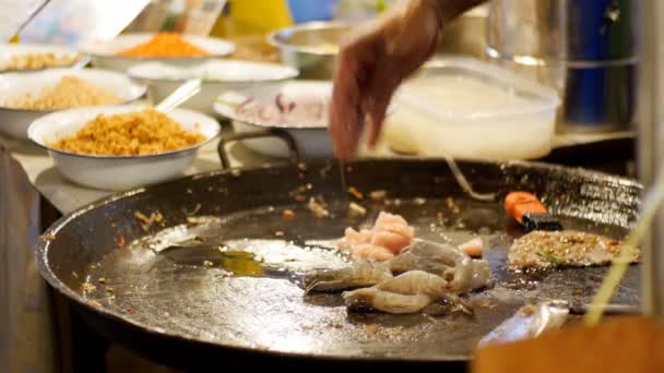 Comida callejera asiática. Mariscos Camarones, calamares, pulpo cocinando en una sartén grande. Tailandia . — Vídeos de Stock