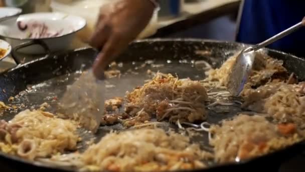 Asian Street food. Fisk och skaldjur, ris nudlar med ägg matlagning på en stor stekpanna. Slow Motion. Thailand — Stockvideo