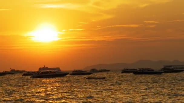 Κόκκινο ηλιοβασίλεμα στη θάλασσα με τα σκάφη σιλουέτα που λικνίζονται στα κύματα. Ταϊλάνδη. Πατάγια — Αρχείο Βίντεο