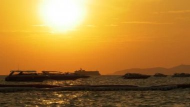 Kırmızı günbatımı dalgalar üzerinde sallanan siluet tekne ile denizde. Tayland. Pattaya