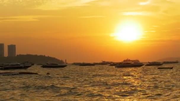 Κόκκινο ηλιοβασίλεμα στη θάλασσα με τα σκάφη σιλουέτα που λικνίζονται στα κύματα. Ταϊλάνδη. Πατάγια — Αρχείο Βίντεο