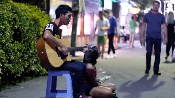 Asya adam geceleri Pattaya Street yürüyüş ünlü gitar oynamak. Tayland — Stok video