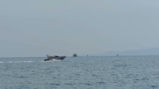 Motorbåt seglar längs vågorna i havet mot bakgrund av ön Koh Larn. Thailand — Stockvideo