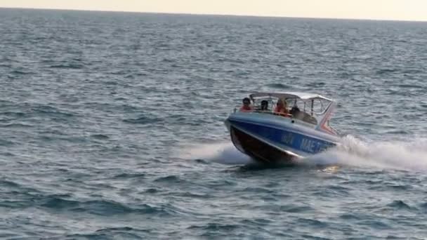 Моторная лодка с людьми плавает вдоль волн в море. Паттайя, Таиланд — стоковое видео