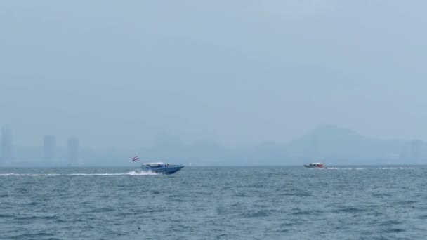 El barco a motor navega a lo largo de las olas en el mar contra el telón de fondo de la isla Koh Larn. Tailandia — Vídeos de Stock