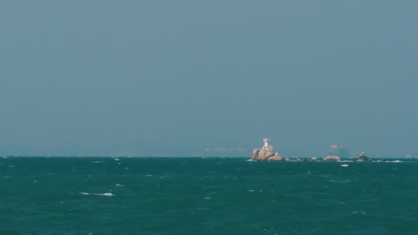 Vuurtoren op een rots in het midden van de zee — Stockvideo
