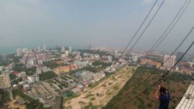 Pattaya City kuleden atlamak. Adam çatıdan kablo gider. Tayland