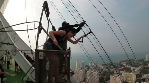 Extrema hopp från Pattaya City tornet. Kvinna går ner kabeln från taket — Stockvideo