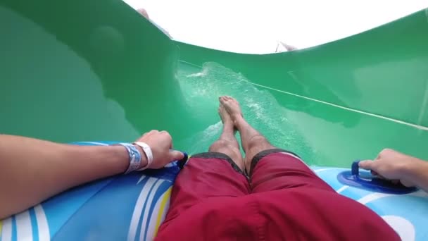 Water dia's pov. Man op opblaasbare ring daalt met glijbanen. Slow Motion — Stockvideo