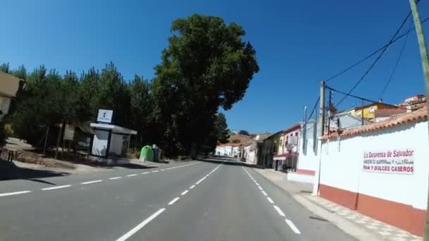 Motocyklista na koni po asfaltové silnici v poušti, přes malé městečko s bílými domy ve Španělsku — Stock video