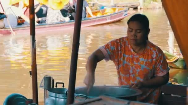 Mercado flotante de Pattaya. Una vendedora en un bote pequeño está preparando comida. Tailandia — Vídeo de stock