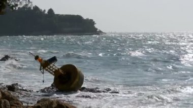 Eski paslı Sarı şamandıra bir kayalık plaj kıyısında yer almaktadır. Tayland. Pattaya. Asya