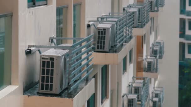 Clădire modernă cu mai multe etaje, cu multe aparate de aer condiționat în ploaie — Videoclip de stoc