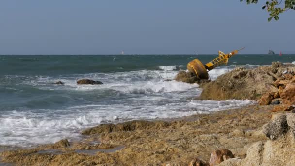 Régi rozsdás-sárga bója egy sziklás strand partján fekszik. Thaiföld. Pattaya. Asia — Stock videók